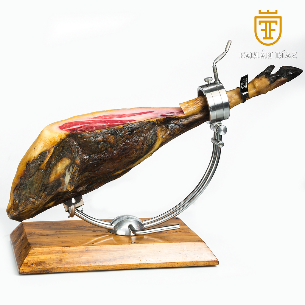 Se muestra un jamón sobre un cortador. Al jamón se le ha cortado  se aprecia el jamón y la grasa de la pata.