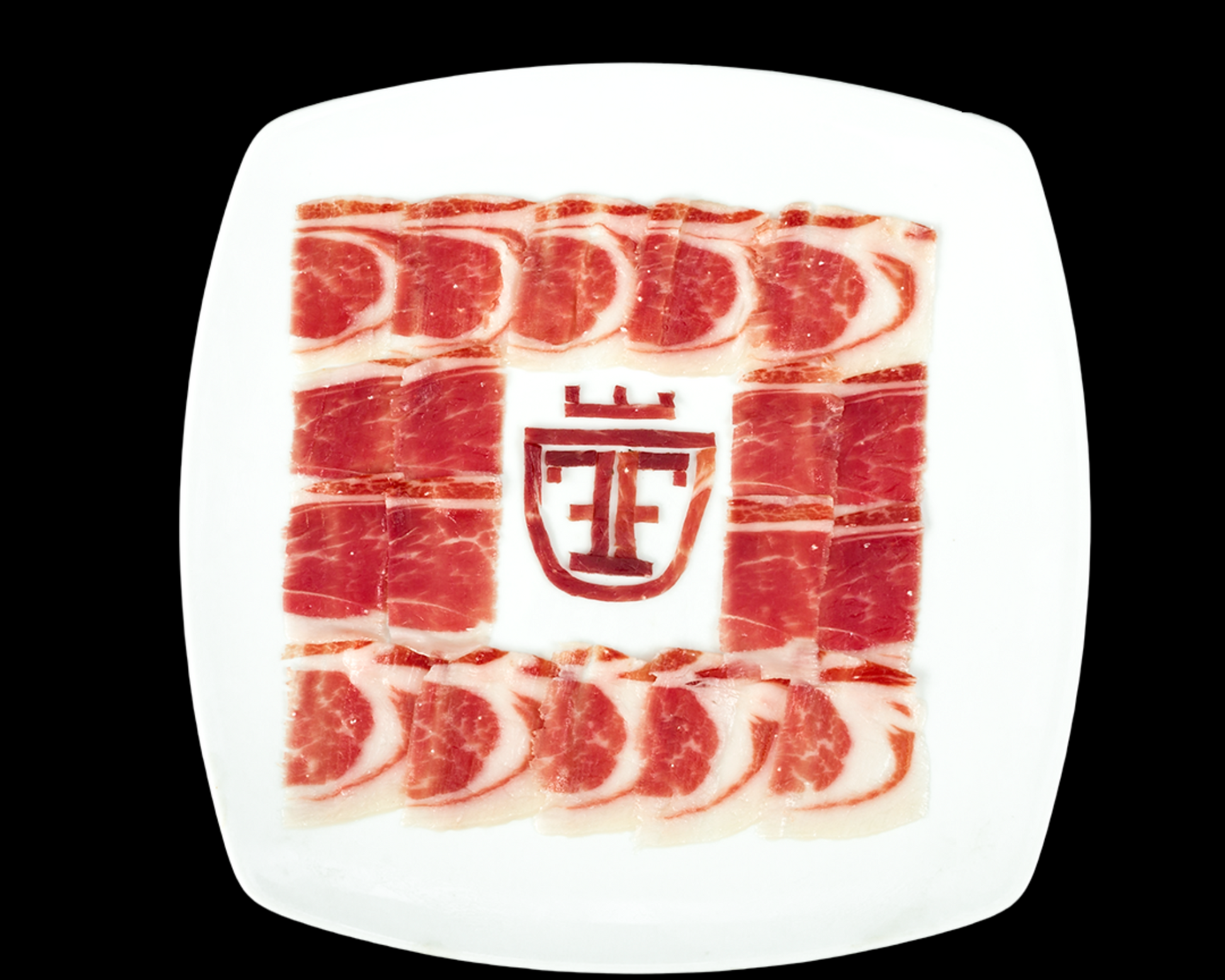 Se muestra un plato blanco con varias lonchas de paleta ibérica. En el centro se muestra el logo del producto.