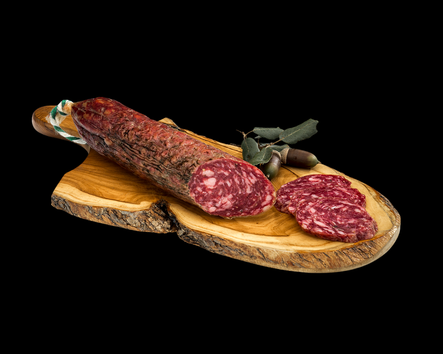 Se muestra un salchichón cular cortado con varias rodajas sobre una tabla de madera sobre un fondo negro.