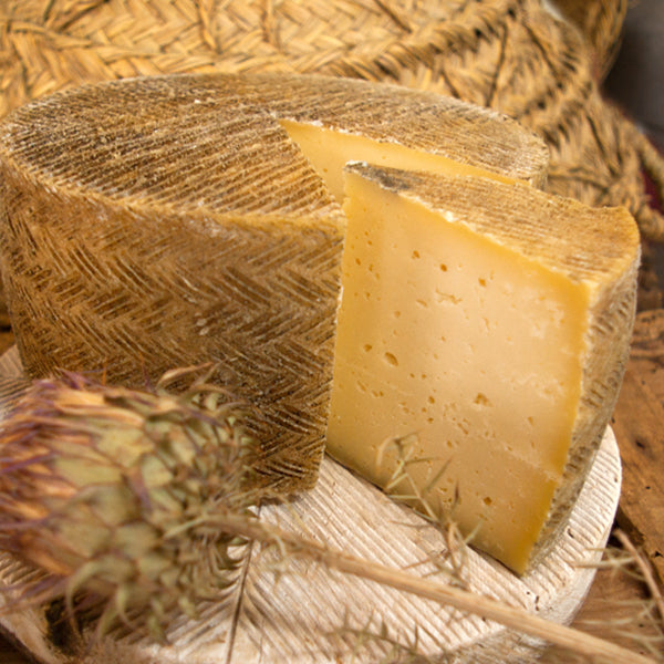 Se muestra un queso y una cuña partida.