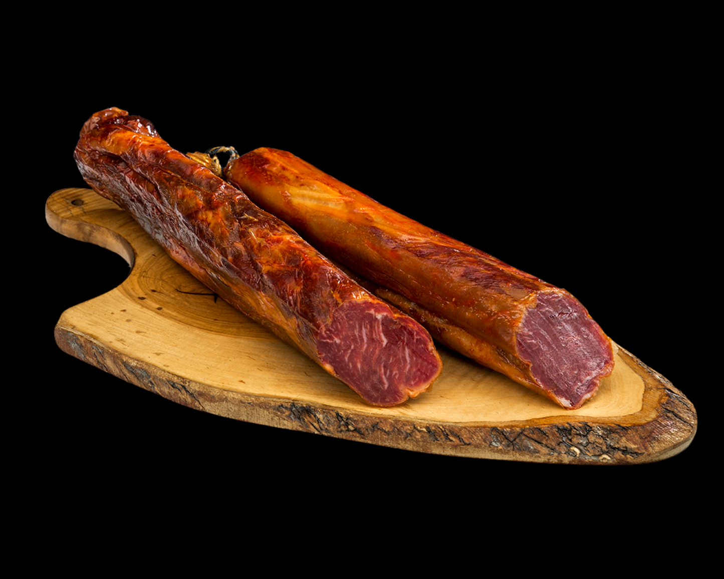 Se muestra una caña de lomo cortada con varias rodajas sobre una tabla de madera. El aspecto e muy apetecible, su ligeras vetas de grasa.