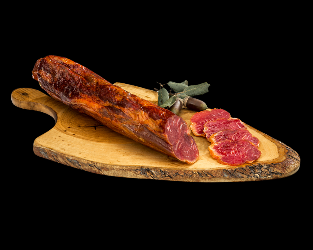 Se muestra una caña de lomo cortada con varias rodajas sobre una tabla de madera. El aspecto e muy apetecible, su ligeras vetas de grasa.