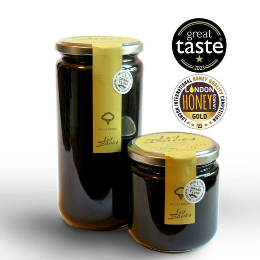 Se muestran dos tarros de miel, uno de 1kg y otro de 0,5kg, ambos con su etiqueta. También se muestra los premios recibidos en los Great Taste y en el London Honey Awards.