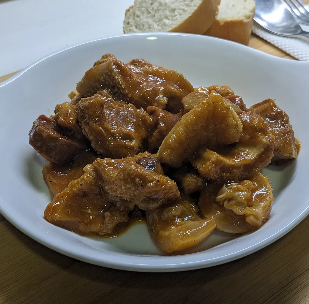 Se muestra un plato blanco un callos artesanales en salsa.