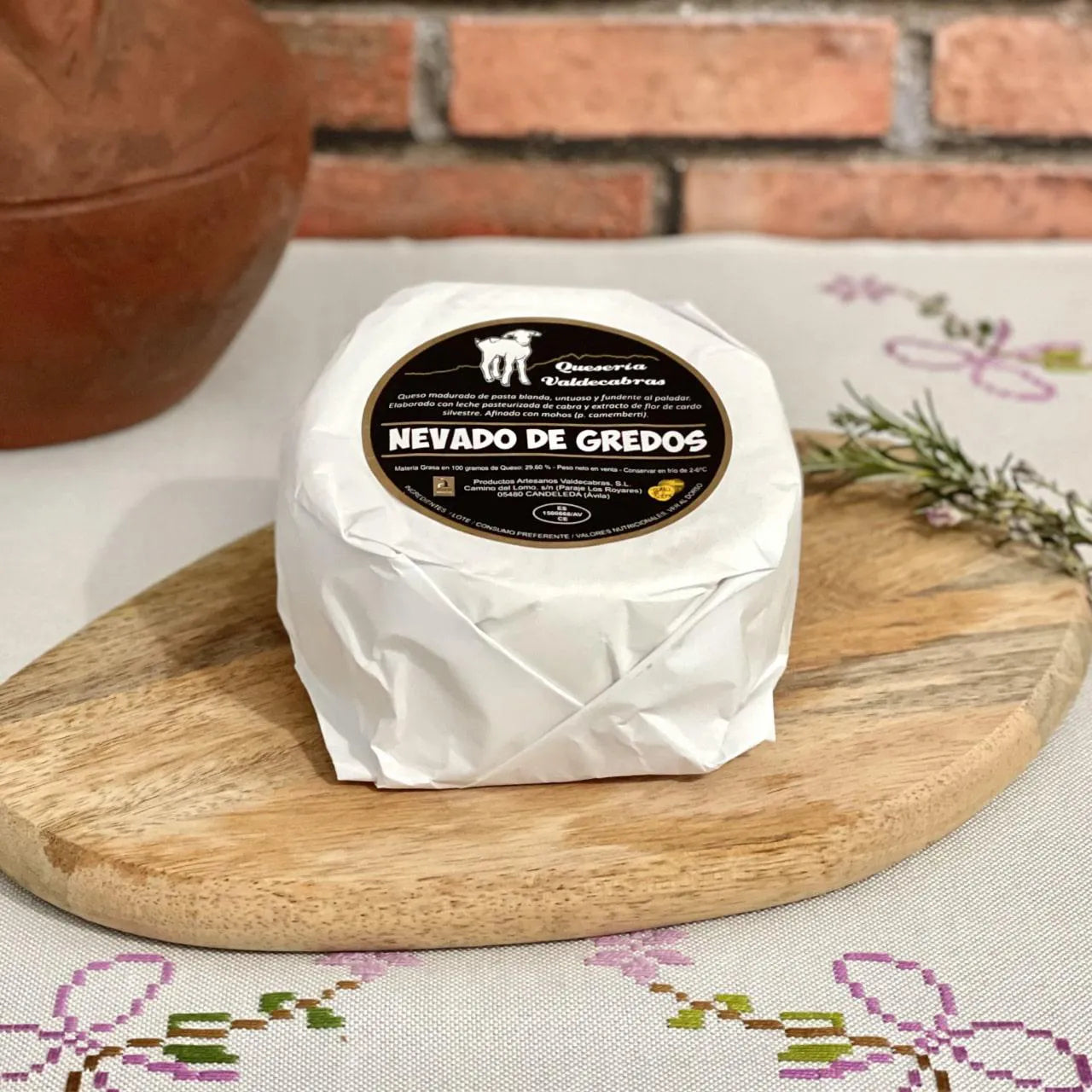 Se muestra un eso Nevado de Gredos envuelto en su papel y sobre una tabla de madera.