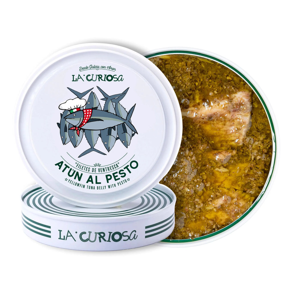 Se muestran dos latas de atún al pesto y una de ellas con la tapa quitada, mostrándose el atún con la salsa de pesto.