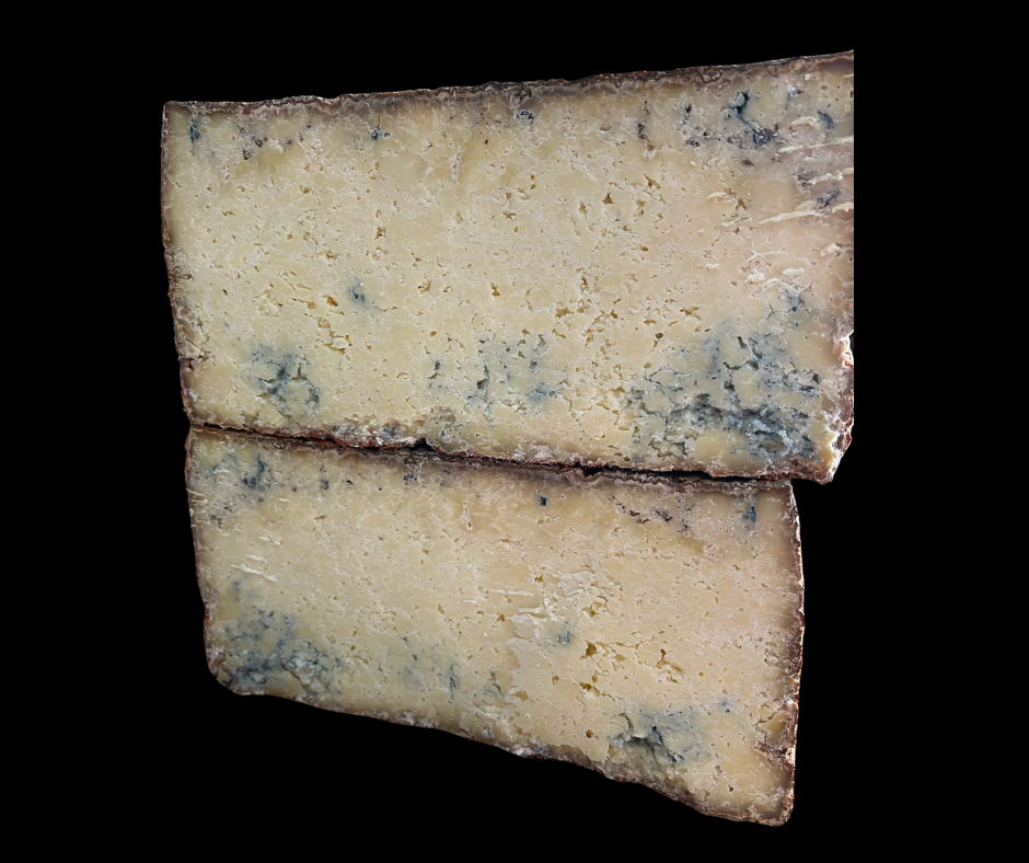 Se muestra un queso partido a la mitad con una mitad sobre la otra. El aspecto es el de un queso viejo con vetas azules.