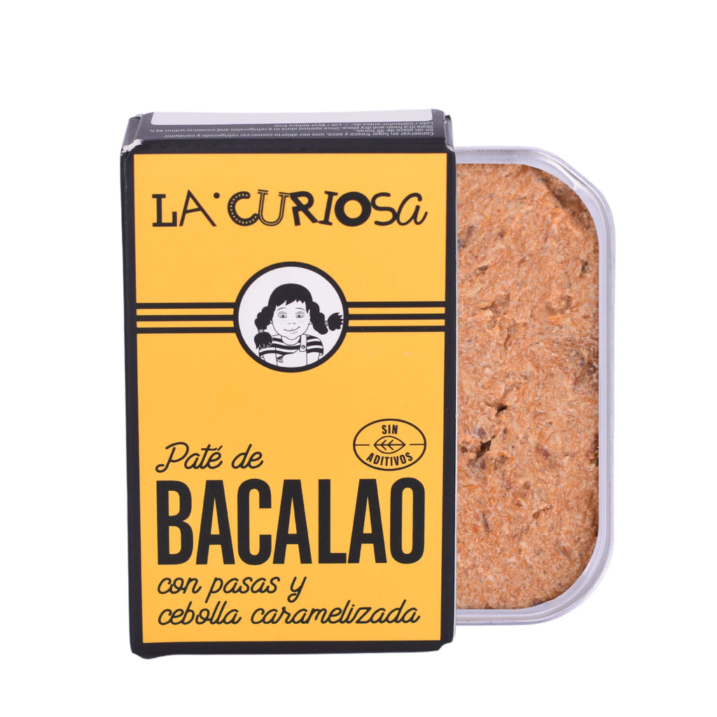 Se muestra una lata de paté de bacalao con su caja amarilla. Se aprecia la textura untuosa del paté.