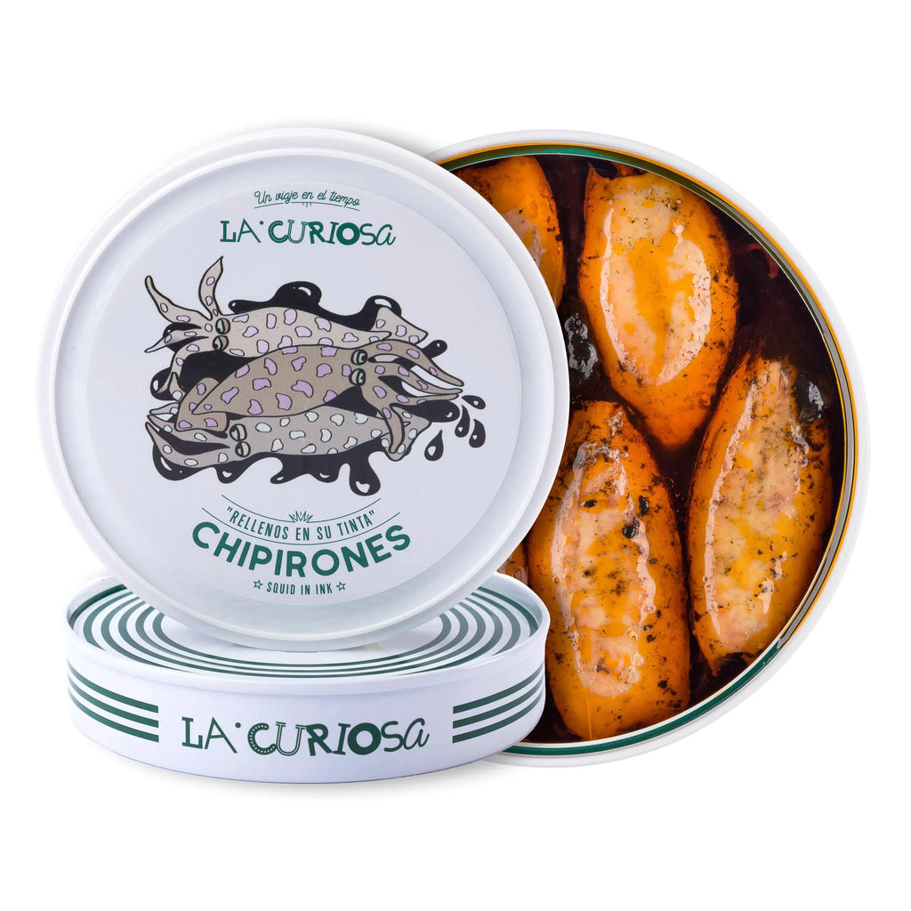 Se muestran dos latas de chipirones en su tinta, con una de ellas sin tapa en la que se aprecian los chipirones y la tinta negra.