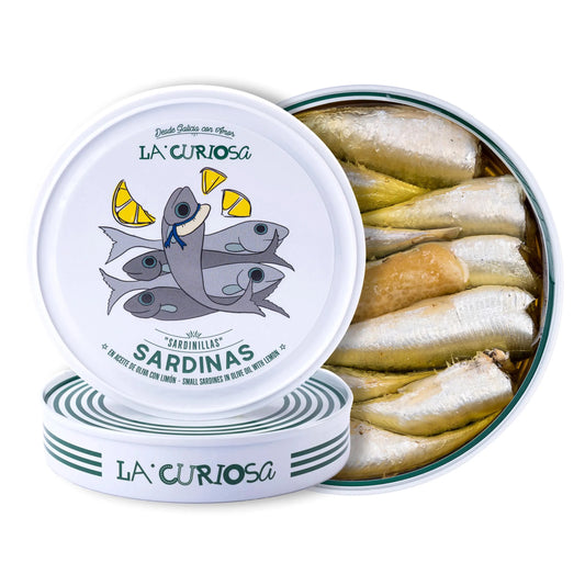 Se muestra una lata de sardinillas blanca abierta, y dentro de la lata, varias sardinillas.