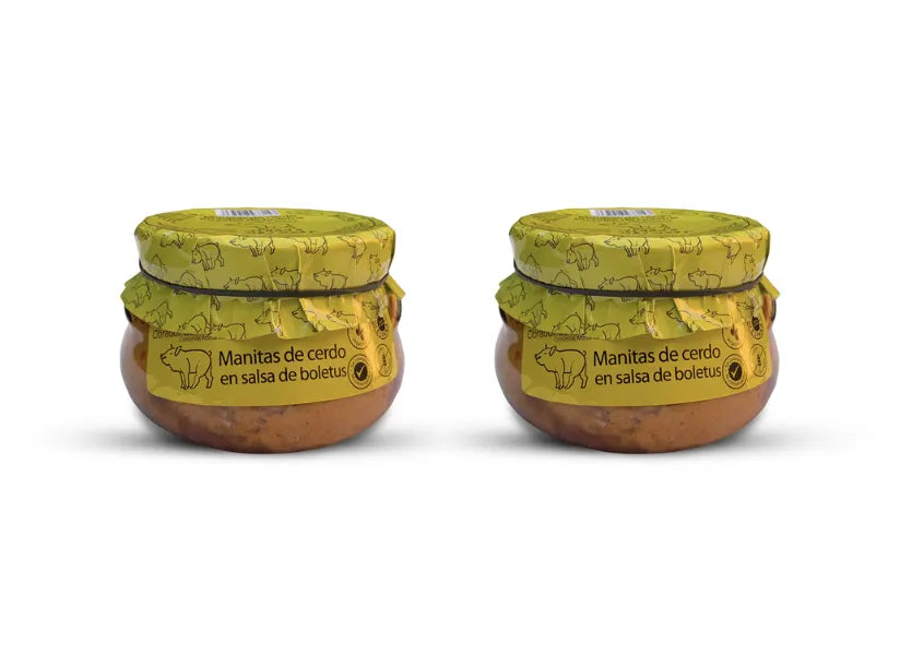 Se muestran dos botes de manitas de cerdo con la etiqueta del productor de color amarillo en la base superior del bote.