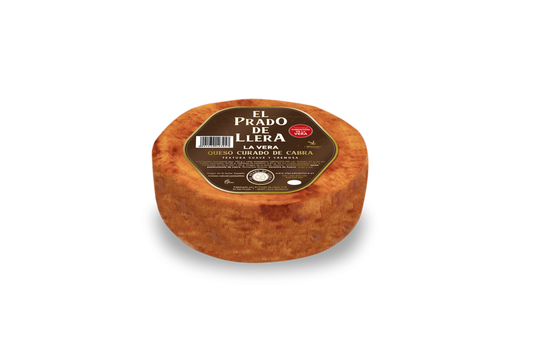 Se muestra el queso con su corteza rojiza por el pimentón con su etiqueta marrón en la parte superior del queso.