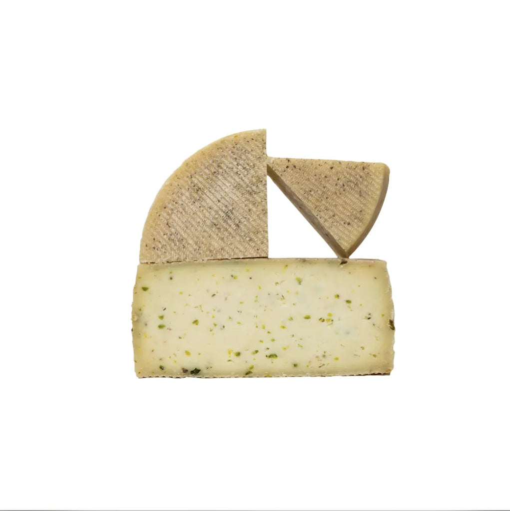 Queso de oveja con trozos de pistacho en cuñas con distinto tamaño.