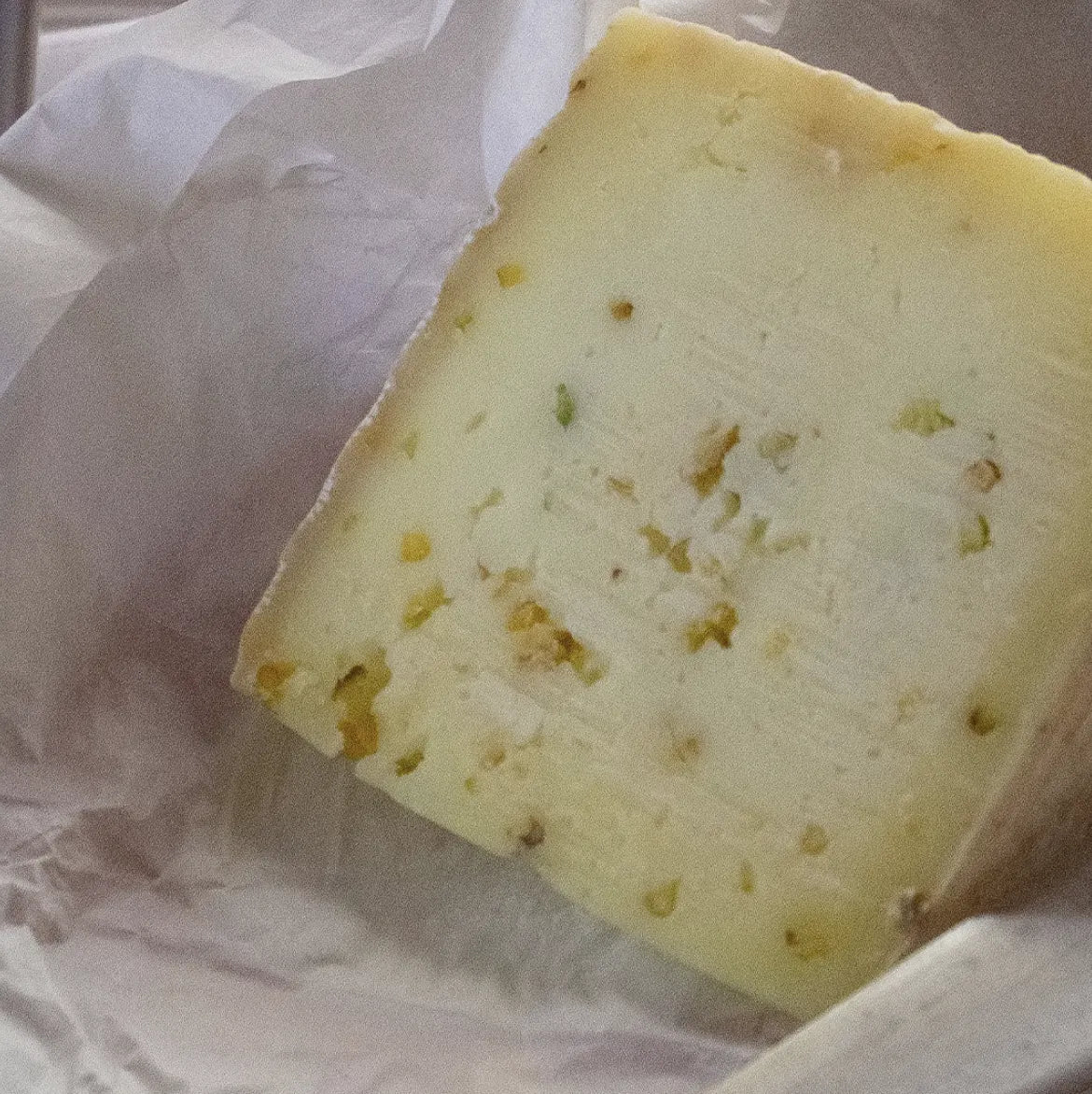 Cuña de queso con trozos de pistacho. 