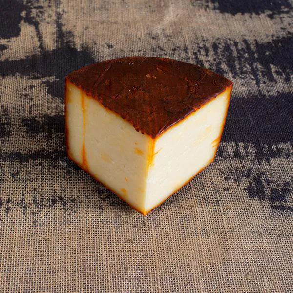 Cuña de queso con corteza roja del pimentón.