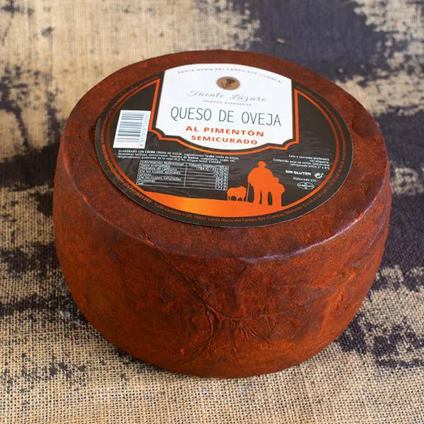 Queso entero de corteza rojo intenso debido al pimentón. En su base superior está la etiqueta del productor con la información del queso.