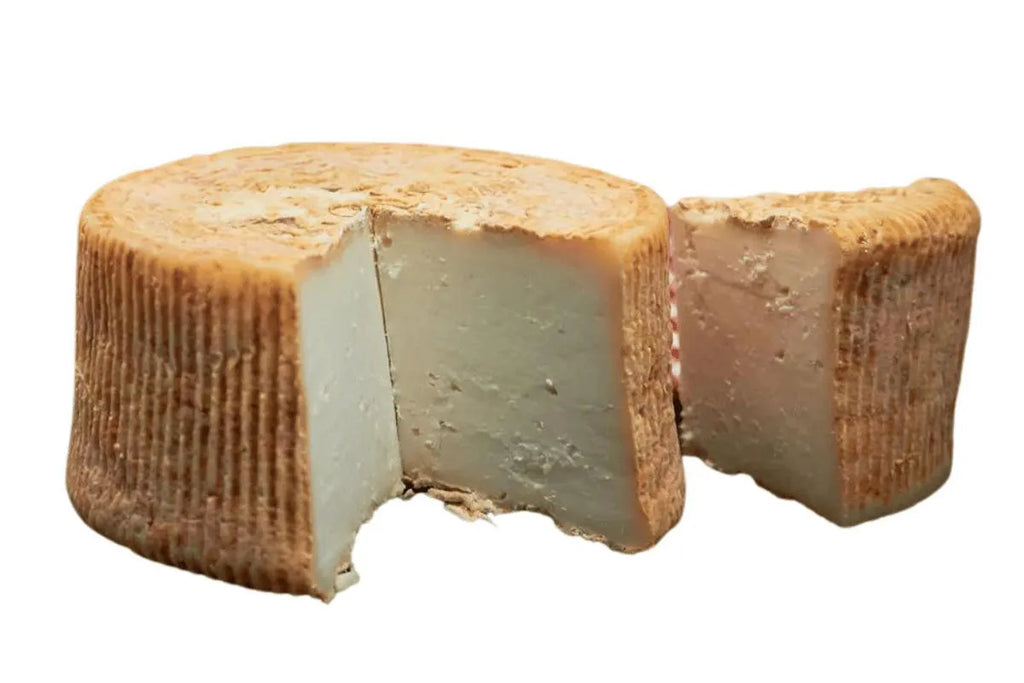 Queso al que se le ha partido una cuña sobre un fondo blanco.