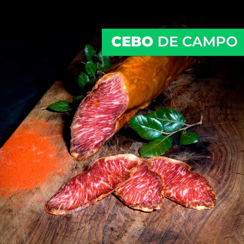 Se muestra un lomo ibérico cortado con varias rodajas sobre una tabla de madera. En el lomo se aprecia su gran veteado.